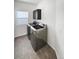 Bright laundry room features modern washer and dryer with tile floor and a wall cabinet at 6400 N Windfield Ave, Parker, CO 80134