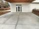 Concrete patio and doorway with a white stucco wall and wood ceiling above at 6400 N Windfield Ave, Parker, CO 80134