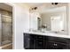 Bathroom with double vanity, dark cabinets, and quartz countertop at 9310 E 61St Ave, Denver, CO 80238