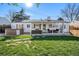 Expansive backyard features a hot tub, covered patio area, and stone walkway in a well-maintained lawn at 3350 S Forest St, Denver, CO 80222