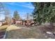 Landscaped backyard with mature trees, a covered patio and brick home at 6261 S Adams Dr, Centennial, CO 80121