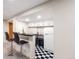 Basement bar area featuring bar seating, black and white flooring and a refrigerator at 6261 S Adams Dr, Centennial, CO 80121