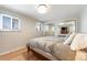 Well-lit bedroom with hardwood floors, a comfortable bed, and mirrored closet doors at 6261 S Adams Dr, Centennial, CO 80121
