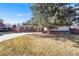 Attractive single-story home featuring a brick facade and mature tree in the landscaped front yard at 6261 S Adams Dr, Centennial, CO 80121