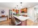 Bright kitchen features stainless steel appliances, a large island with counter seating, and hardwood floors at 6261 S Adams Dr, Centennial, CO 80121