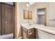 Bathroom with wood vanity and large mirror, offering a glimpse into the bedroom at 9651 W Cornell Pl, Lakewood, CO 80227