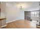 Spacious living room with hardwood floors, a stone accent wall, and a modern chandelier at 9651 W Cornell Pl, Lakewood, CO 80227