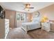 Light-filled bedroom with white furniture set, ceiling fan and plush carpet at 3780 S Quemoy Way, Aurora, CO 80018