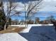Backyard view of a snow-covered field, bare trees, and distant homes at 2210 S Vaughn Way # 103, Aurora, CO 80014