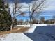 Winter backyard view of a snow-covered field, bare trees, and homes in the distance at 2210 S Vaughn Way # 103, Aurora, CO 80014