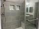 Modern bathroom shower features gray tile, built-in niche, and glass door at 2210 S Vaughn Way # 103, Aurora, CO 80014