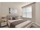 Calm bedroom featuring a large bed, neutral bedding, and a window with blinds at 2210 S Vaughn Way # 103, Aurora, CO 80014
