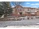 Exterior view of a multi-story home with a brick facade and snow-covered ground at 2210 S Vaughn Way # 103, Aurora, CO 80014