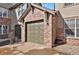 Attached garage with brown door and brick accents on a sunny day at 2210 S Vaughn Way # 103, Aurora, CO 80014