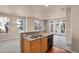 Open-concept kitchen with stainless steel sink, black dishwasher, and access to the living room at 2210 S Vaughn Way # 103, Aurora, CO 80014