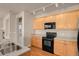 Modern kitchen with stainless sink, black appliances and wooden cabinets at 2210 S Vaughn Way # 103, Aurora, CO 80014