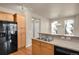 Bright kitchen featuring stainless steel sink, black appliances, and light wood cabinetry at 2210 S Vaughn Way # 103, Aurora, CO 80014