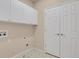 Bright laundry room featuring white cabinets, closet, and tile floors with geometric accents at 2210 S Vaughn Way # 103, Aurora, CO 80014
