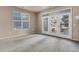 Sunny living room with a window and glass patio doors, neutral color paint at 2210 S Vaughn Way # 103, Aurora, CO 80014