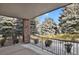 A brick patio with a metal railing overlooks snowy shrubs and pine trees at 2210 S Vaughn Way # 103, Aurora, CO 80014