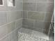 Modern bathroom featuring a walk-in shower with stylish gray tiling, a built-in bench and a niche at 2210 S Vaughn Way # 103, Aurora, CO 80014