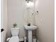 Well-lit half bathroom with pedestal sink and white fixtures at 11350 W Grand Ave, Littleton, CO 80127