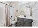 Bright bathroom featuring vanity with gray cabinets, toilet, and shower/bath combo with a stylish curtain at 11350 W Grand Ave, Littleton, CO 80127