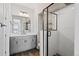 Modern bathroom featuring stylish vanity with gray cabinets, a large mirror, and a glass-enclosed shower at 11350 W Grand Ave, Littleton, CO 80127