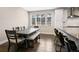 Dining area featuring a large wooden table, bench seating, and natural light from the windows at 11350 W Grand Ave, Littleton, CO 80127