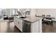 Modern kitchen with island, stainless steel dishwasher, and open layout to the living area at 11350 W Grand Ave, Littleton, CO 80127