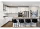 Beautiful kitchen with white cabinets, stainless steel appliances and center island with seating at 11350 W Grand Ave, Littleton, CO 80127