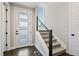 A modern staircase with carpeted steps, a window and a stylish, partially frosted door at 11350 W Grand Ave, Littleton, CO 80127