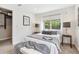 Cozy bedroom featuring a large window, plush carpet, and a comfortable bed with throw blanket at 3064 S Grape Way, Denver, CO 80222