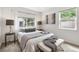 Bright bedroom featuring neutral decor, large window, and cozy bed with grey throw blanket at 3064 S Grape Way, Denver, CO 80222