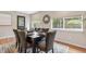 This dining room boasts warm wood floors, large windows, and a dark wood table at 3064 S Grape Way, Denver, CO 80222