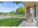 Inviting front porch with a stone pillar, white bench, and well-manicured lawn at 3064 S Grape Way, Denver, CO 80222