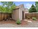 Backyard shed with rustic barn door and surrounding rock and mulch landscaping at 3064 S Grape Way, Denver, CO 80222