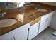 Dual-sink vanity with granite counter top and white cabinetry at 3548 S Hillcrest Dr # 2, Denver, CO 80237
