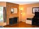 Cozy living room featuring a brick fireplace and mantel mirror, plus gleaming hardwood floors at 3548 S Hillcrest Dr # 2, Denver, CO 80237