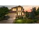Inviting two-story home with a well-manicured lawn, beautiful landscaping, and a two-car garage at dusk at 20964 E Greenwood Pl, Aurora, CO 80013