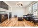 Spacious living room with hardwood floors, a modern fireplace, large windows, and dark, modern furniture at 20964 E Greenwood Pl, Aurora, CO 80013
