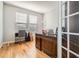 Well-lit home office with a large desk, hardwood floors, and French door entry at 20964 E Greenwood Pl, Aurora, CO 80013