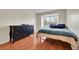Bright bedroom featuring a wooden dresser, hardwood floors, and a window offering natural light at 14110 E Dickinson Dr # A, Aurora, CO 80014