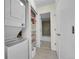 Hallway showing laundry closet with stackable washer/dryer, shelves, and nearby bath at 14110 E Dickinson Dr # A, Aurora, CO 80014