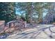 Welcoming entrance to 'The Pines' covenant community with brick signage and landscaped surroundings at 4756 E Pinewood Cir, Centennial, CO 80121