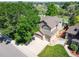 An aerial view of a home with mature trees, large driveway, and a two car garage at 16690 Amberstone Way, Parker, CO 80134
