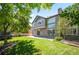 A spacious backyard with lush green grass, a stone patio, and mature trees offers a private outdoor retreat at 16690 Amberstone Way, Parker, CO 80134