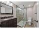 Updated bathroom featuring a sleek glass shower, dark wood vanity with granite counters, and toilet at 16690 Amberstone Way, Parker, CO 80134