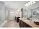 Bright main bathroom featuring dual sinks, large mirrors, and a separate shower and tub at 16690 Amberstone Way, Parker, CO 80134