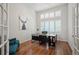 Bright home office with hardwood floors, large windows, and a modern desk, creating an ideal workspace at 16690 Amberstone Way, Parker, CO 80134